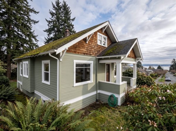 Same Craftsman house after repainting, fresh sage siding and white trim